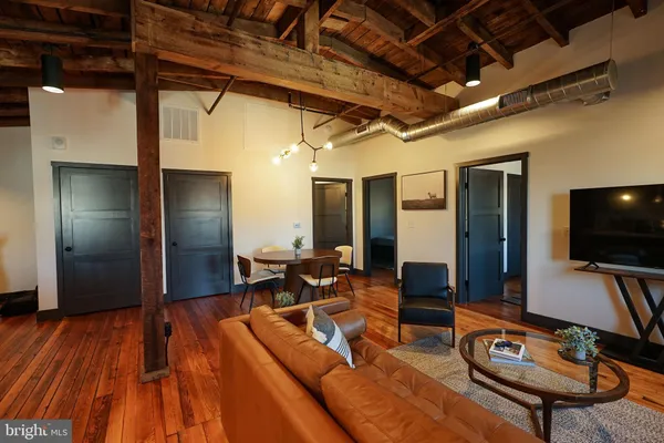 a living room with furniture a flat screen tv and wooden floor