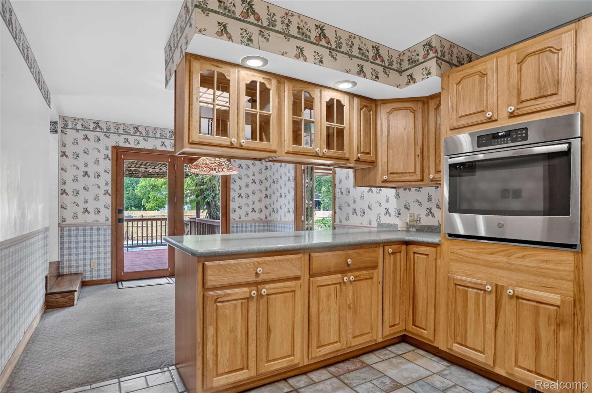1437 East Cook Road Grand Blanc, MI 48439 - Photo 48 of 69 Kitchen featuring wood cabinetry, an integrated stainless steel wall oven, light-toned countertops, and a tile floor