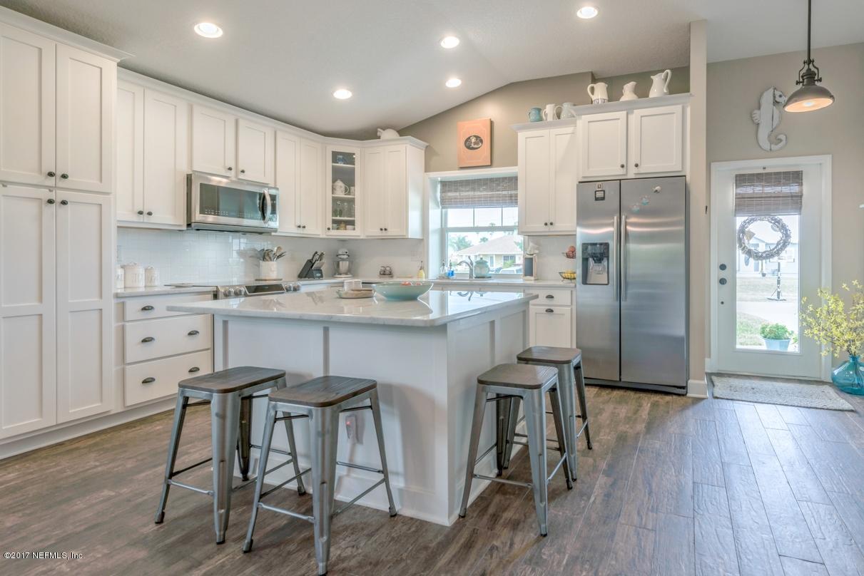 279 Basque Road St. Augustine, FL 32080 - Photo 3 of 29 a kitchen with stainless steel appliances a dining table chairs refrigerator and cabinets