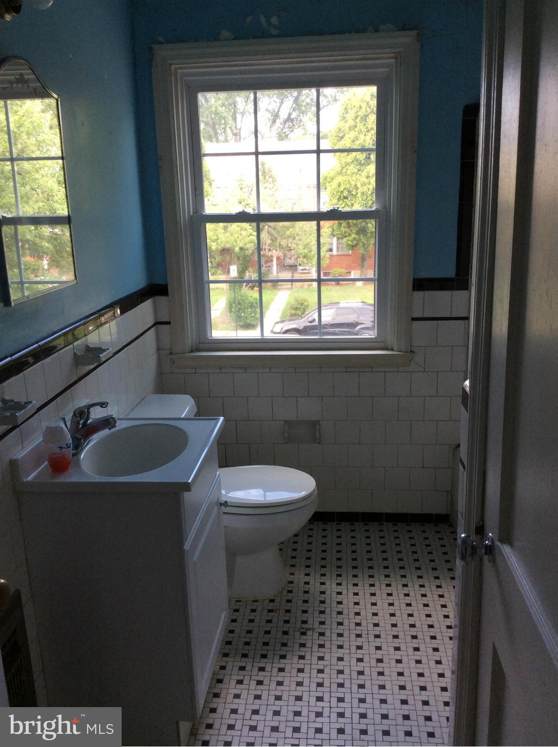 1423 Stonewood Road Baltimore, MD 21239 - Photo 17 of 29 a bathroom with a sink a toilet and window