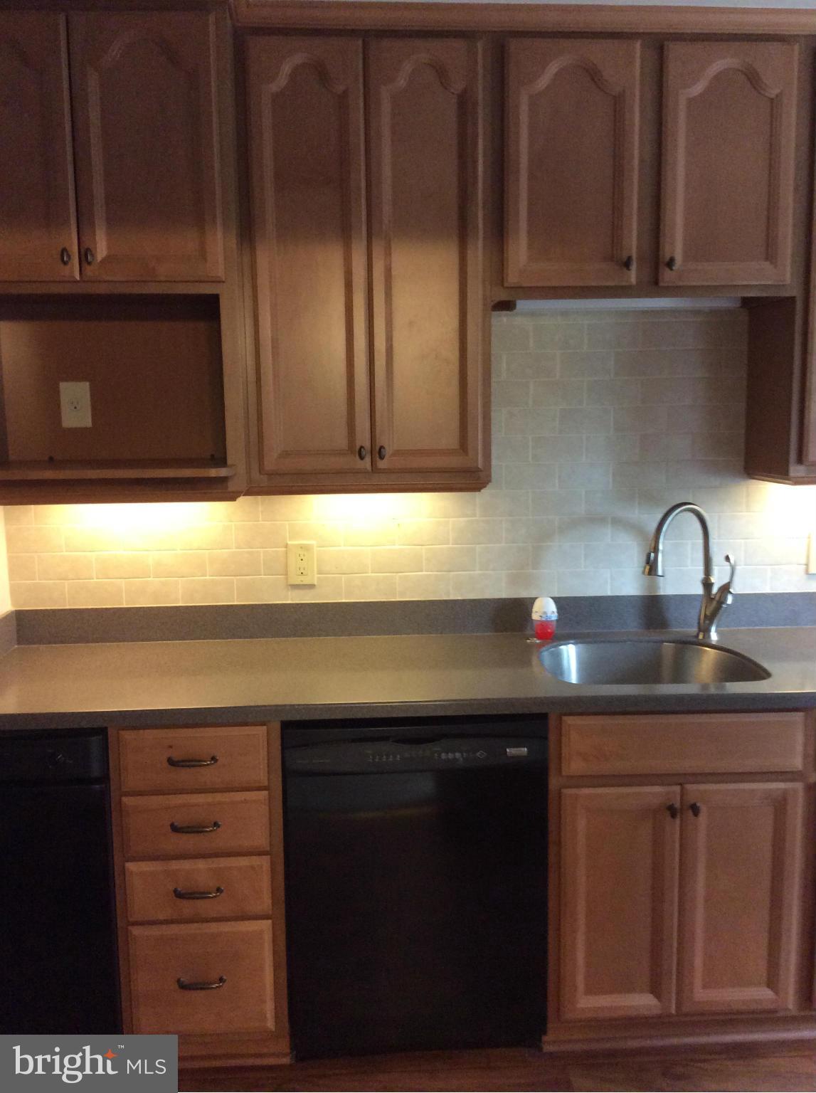 1423 Stonewood Road Baltimore, MD 21239 - Photo 7 of 29 a kitchen with granite countertop wood cabinets and a sink
