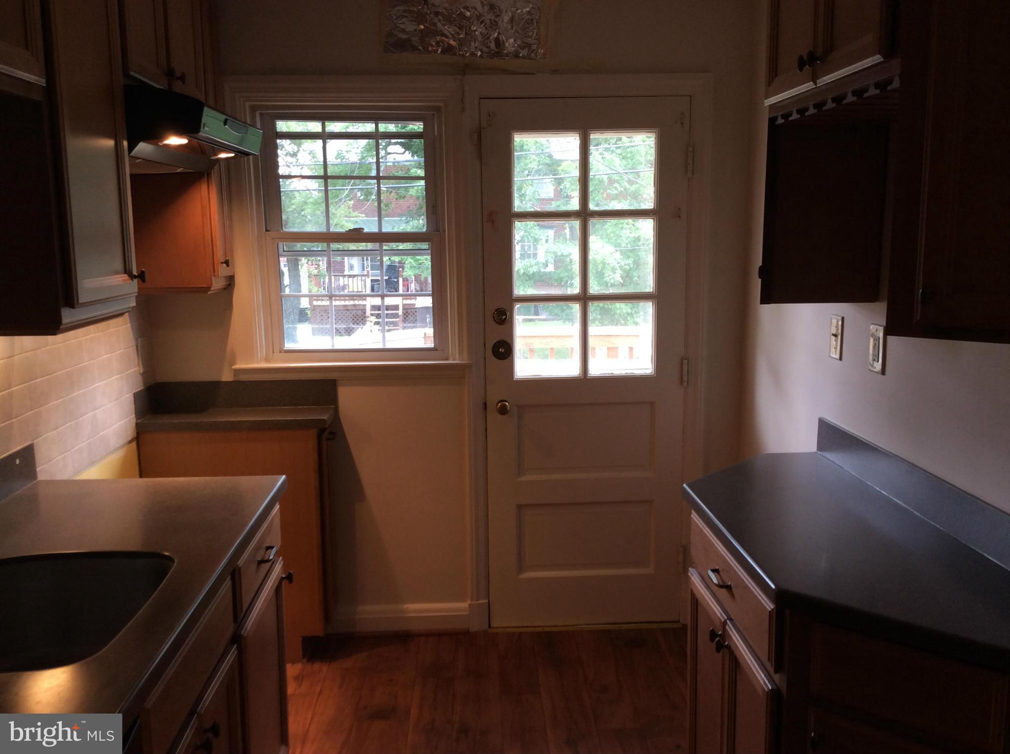 1423 Stonewood Road Baltimore, MD 21239 - Photo 9 of 29 a kitchen with wooden cabinets and a sink