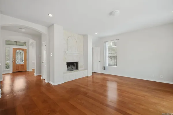 a view of a livingroom with wooden floor and a kitchen