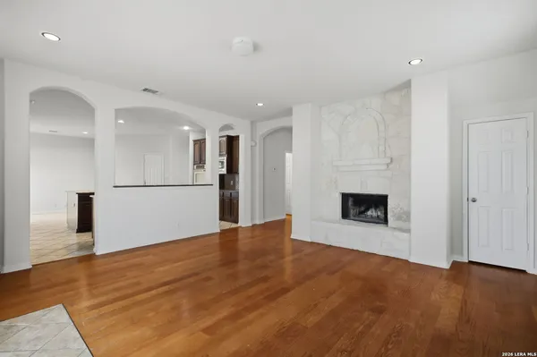 a view of a big room with wooden floor and a kitchen