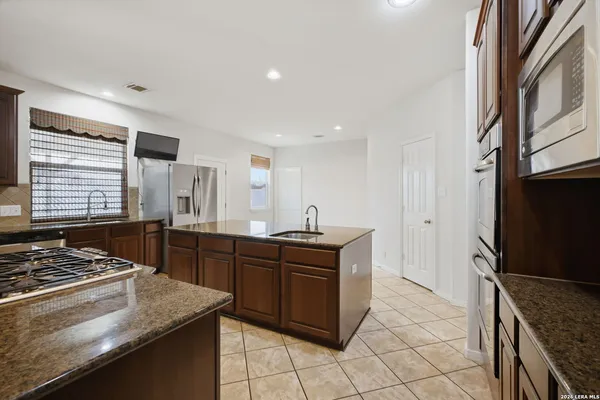 a kitchen with stainless steel appliances granite countertop a stove a sink and a refrigerator