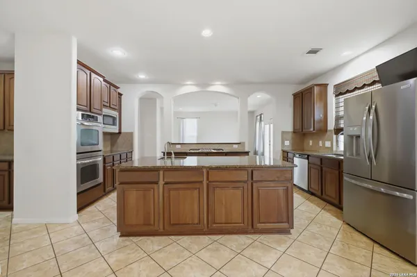 a kitchen with stainless steel appliances granite countertop a refrigerator and a sink