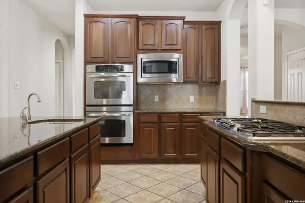 a kitchen with granite countertop a stove sink and microwave