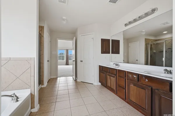 a large bathroom with a sink a mirror and a bathtub
