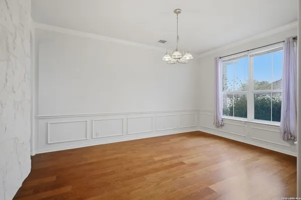 a view of an empty room with a window and chandelier