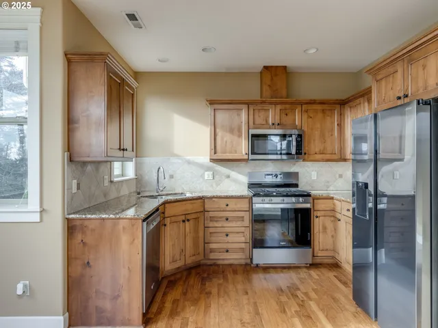 a kitchen with refrigerator a microwave a stove and cabinets