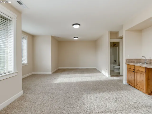 a view of an empty room with a kitchen