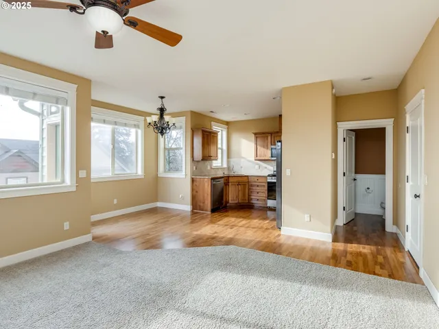 a living room with stainless steel appliances kitchen island granite countertop a refrigerator and a sink