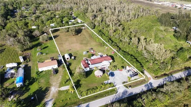 an aerial view of a house with a yard basket ball court and outdoor seating