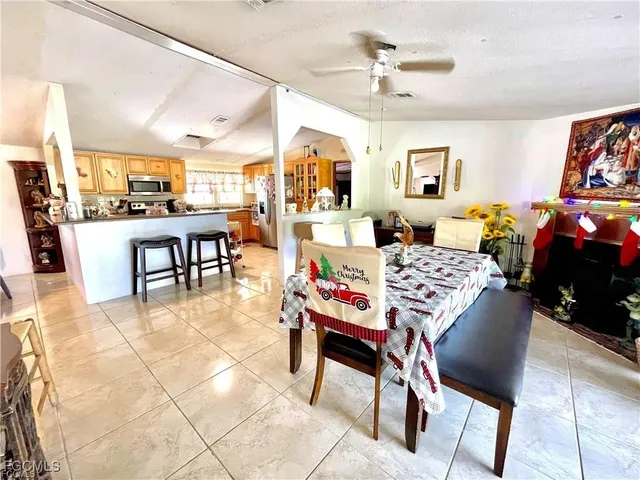 a dining hall with stainless steel appliances lots of white furniture a dining table and chairs