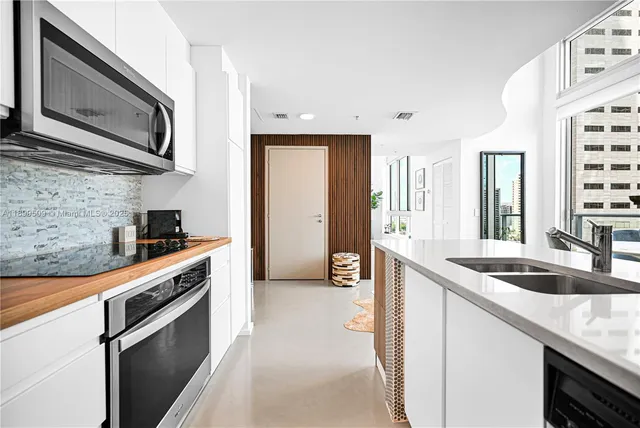 a kitchen with stainless steel appliances white cabinets and a stove top oven