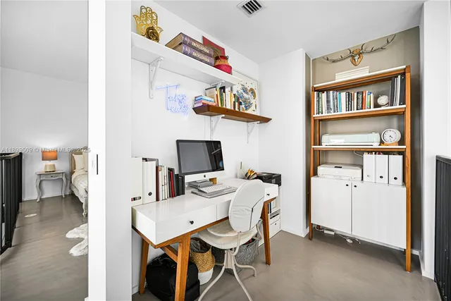 a view of a workspace with furniture and a window