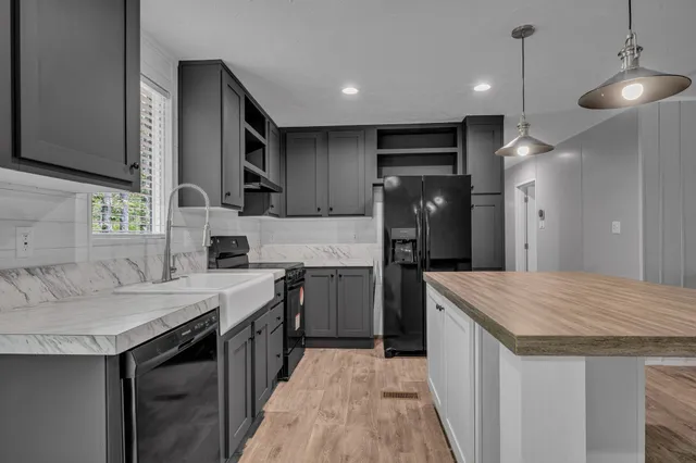 a kitchen with a sink refrigerator and cabinets