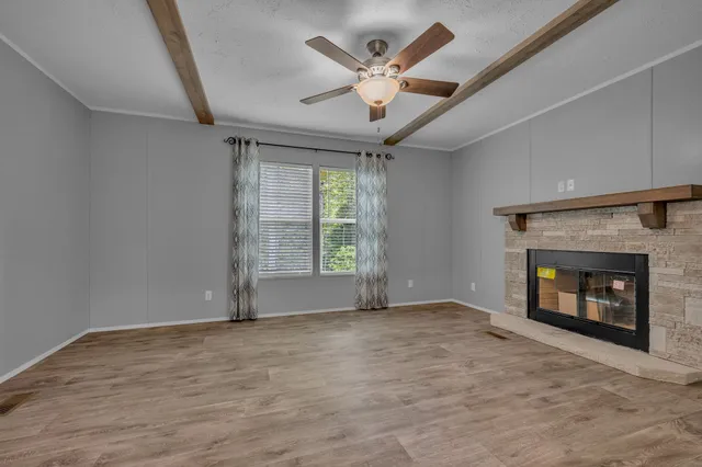 an empty room with windows and fireplace