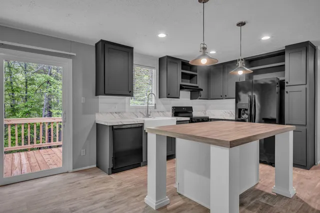 a large kitchen with kitchen island a sink stainless steel appliances and cabinets