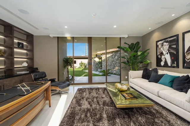 a bedroom with furniture and large windows