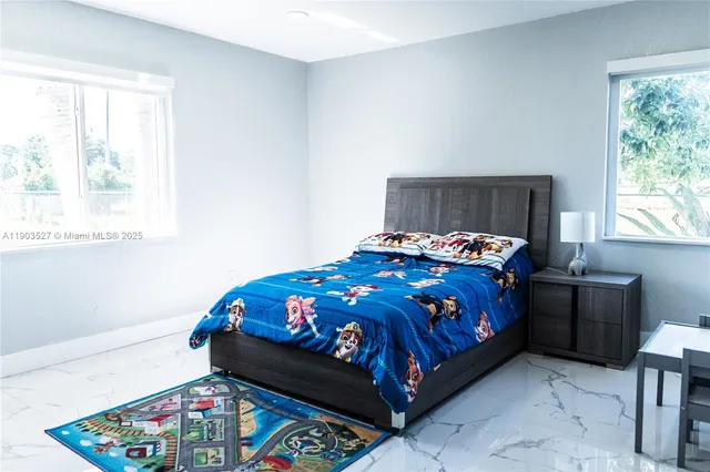 a bed sitting in a bedroom next to a window