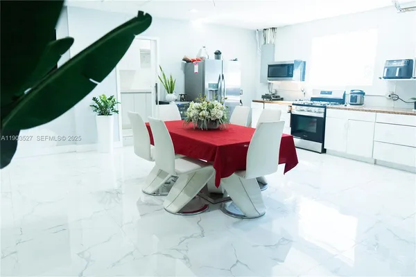 a living room with furniture a flat screen tv and kitchen area