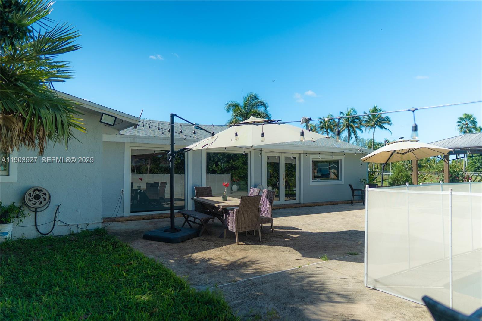 19245 Southwest 188th Street Miami, FL 33187 - Photo 36 of 38 a view of a patio with table and chairs under an umbrella