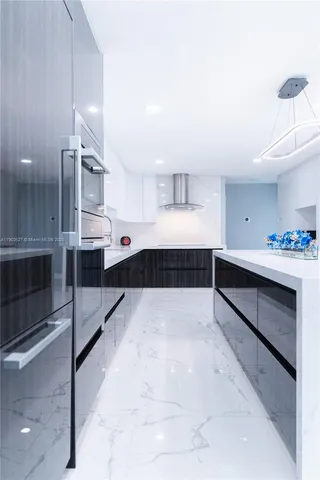 a large white kitchen with a sink and washing machine