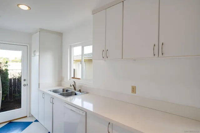 a room with a sink cabinets and a wooden floor