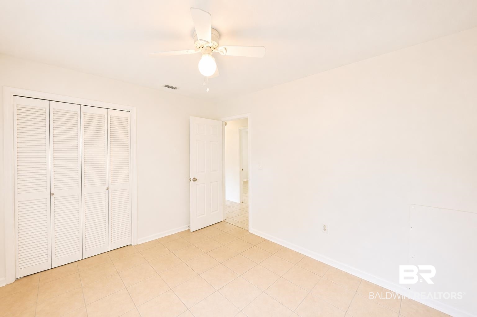 614 East Gate Circle Foley, AL 36535 - Photo 18 of 31 Neutral-toned room featuring a ceiling fan with integrated lighting, bi-fold louvered closet doors, and tile flooring