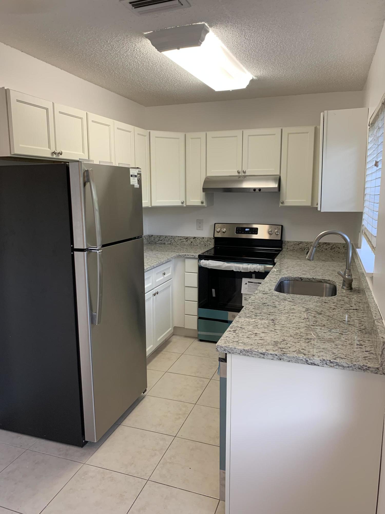 6551 Northeast 7th Avenue, Unit B Boca Raton, FL 33487 - Photo 2 of 12 a kitchen with a refrigerator sink and cabinets