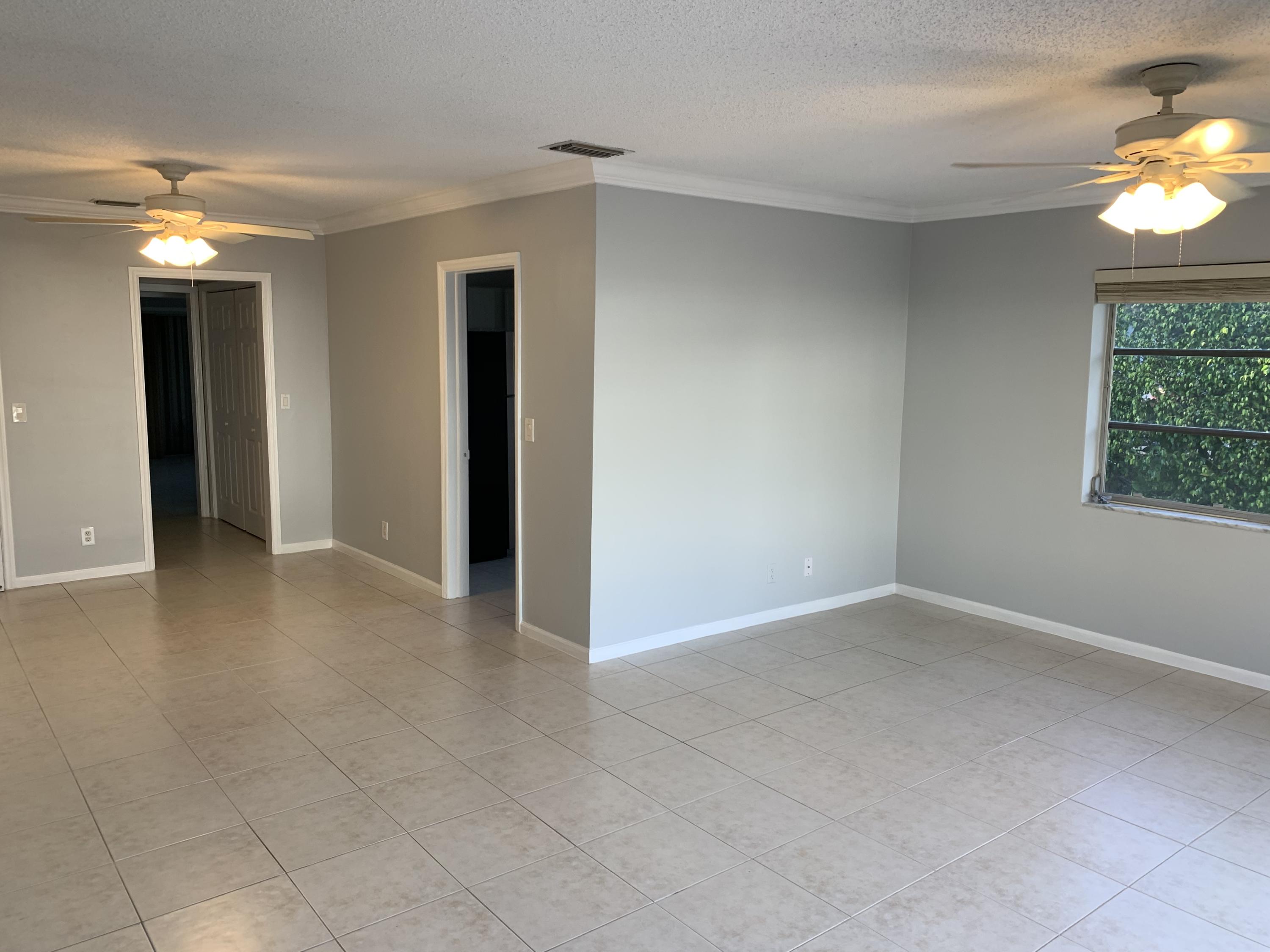 6551 Northeast 7th Avenue, Unit B Boca Raton, FL 33487 - Photo 3 of 12 an empty room with windows and a chandelier fan