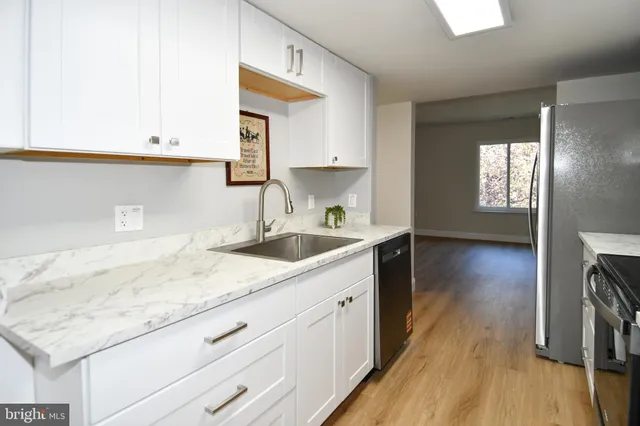 a kitchen with sink cabinets and wooden floor