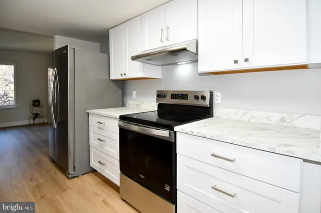 a kitchen with granite countertop white cabinets and white appliances