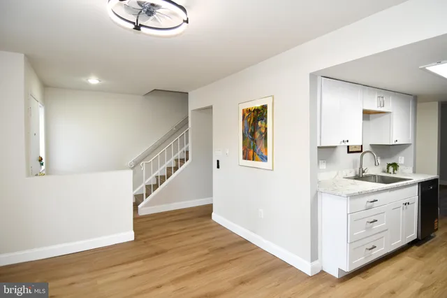a view of entryway and kitchen with wooden floor