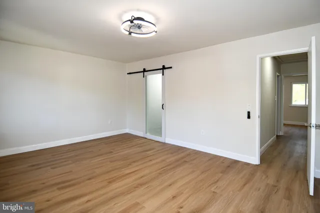 a view of room with a ceiling fan and wooden floor