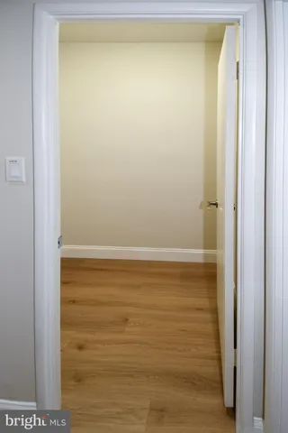 a view of a hallway with wooden floor and stairs