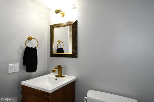 a bathroom with a toilet sink and mirror