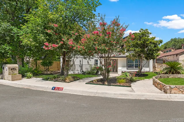 a front view of a house with yard and tree s