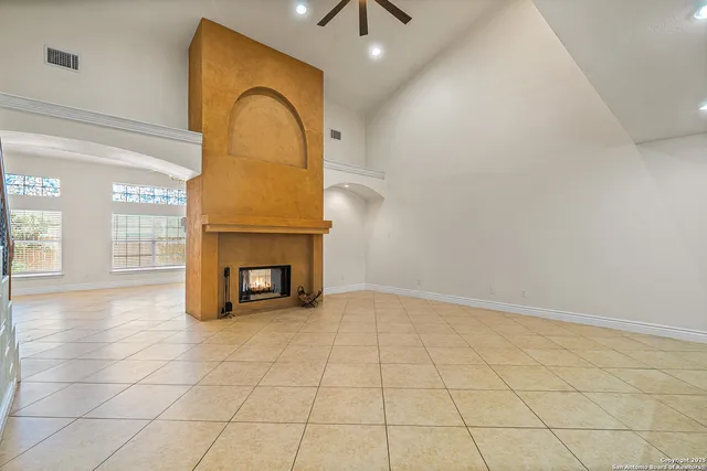 a view of an empty room with a fireplace and a window