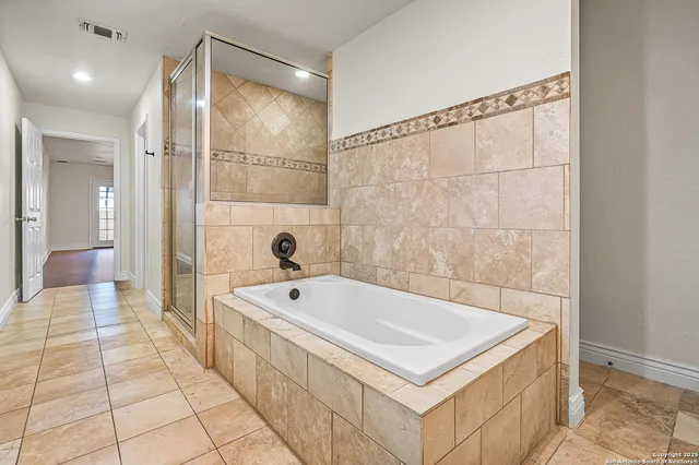 a bathroom with a tub a sink and a shower