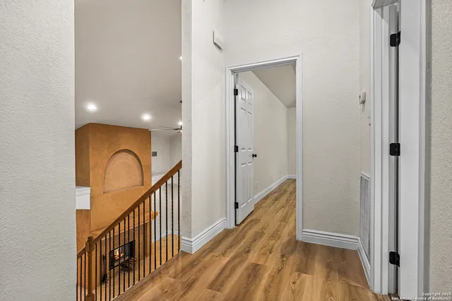 a view of a hallway with wooden floor and staircase