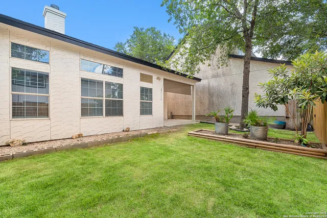 a view of a house with backyard sitting area and garden