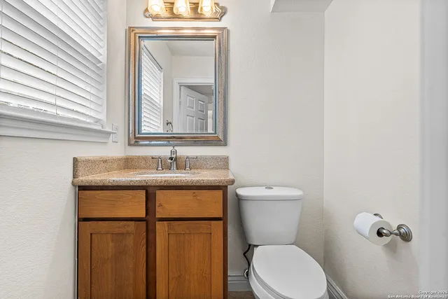 a bathroom with a toilet a sink and mirror