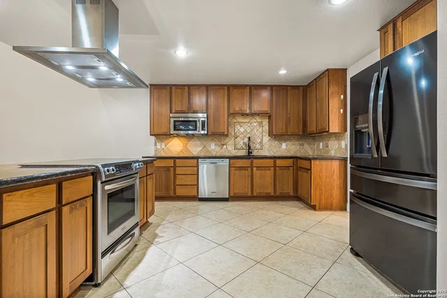 a kitchen with stainless steel appliances granite countertop a refrigerator sink and stove