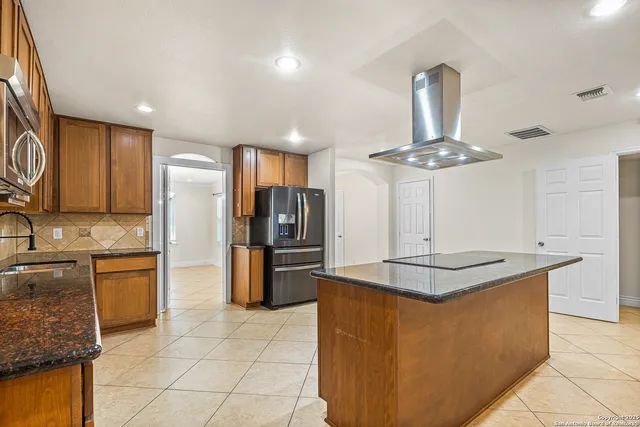 a kitchen with stainless steel appliances granite countertop a sink a stove a refrigerator and cabinets