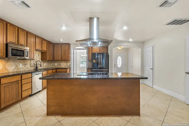a large kitchen with kitchen island a counter top space appliances and cabinets
