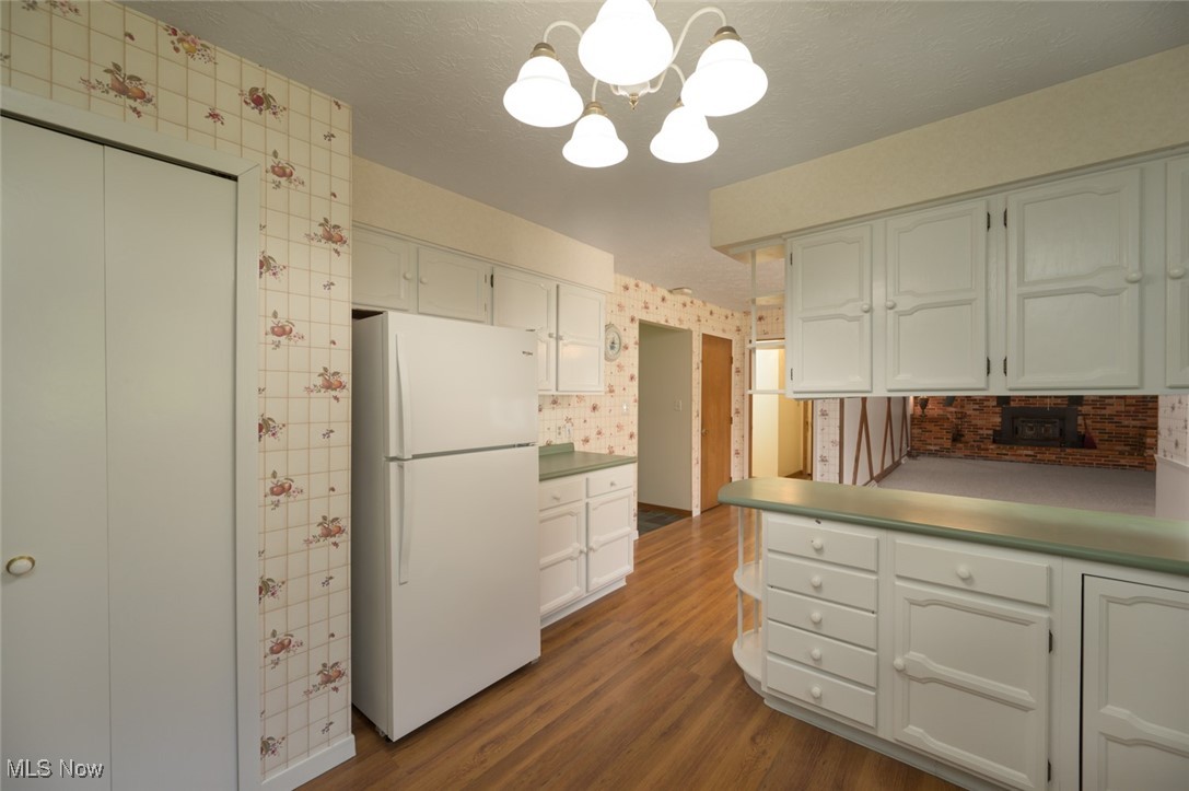 6600 Peck Road Ravenna, OH 44266 - Photo 12 of 50 Kitchen with freestanding refrigerator, a peninsula, dark wood-style flooring, a chandelier, and decorative light fixtures