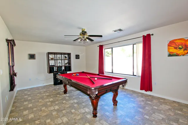 a room with pool table and windows
