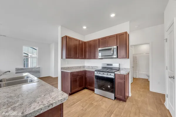 a kitchen with stainless steel appliances granite countertop a stove a sink and a refrigerator